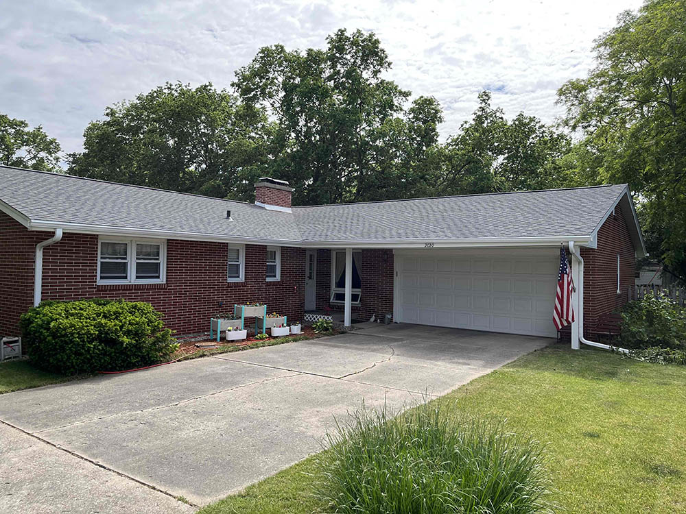 A well-maintained brick home with a new roof and a neatly landscaped front yard