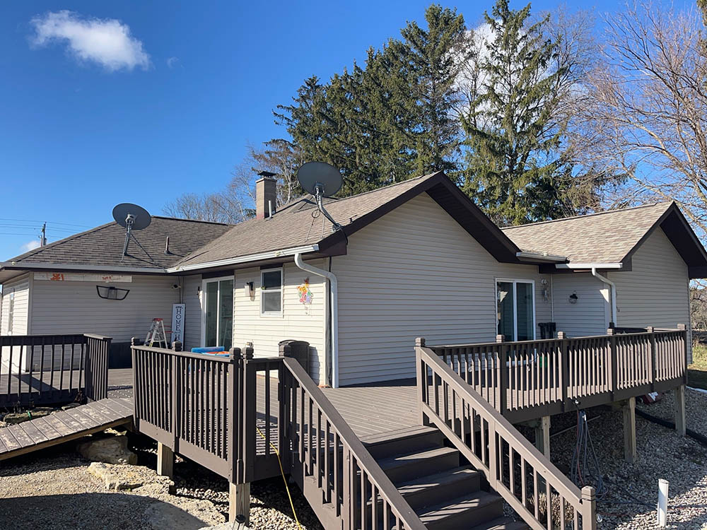 A well-maintained home with a deck and a clear blue sky in the background