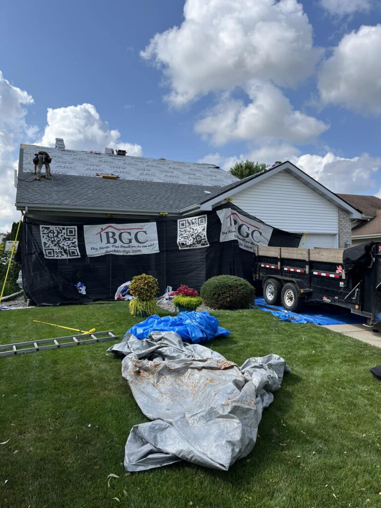 A house undergoing roofing work with a truck and construction materials visible
