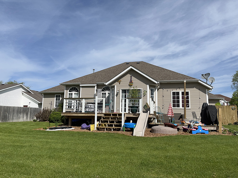 A well-maintained home with a deck and backyard visible