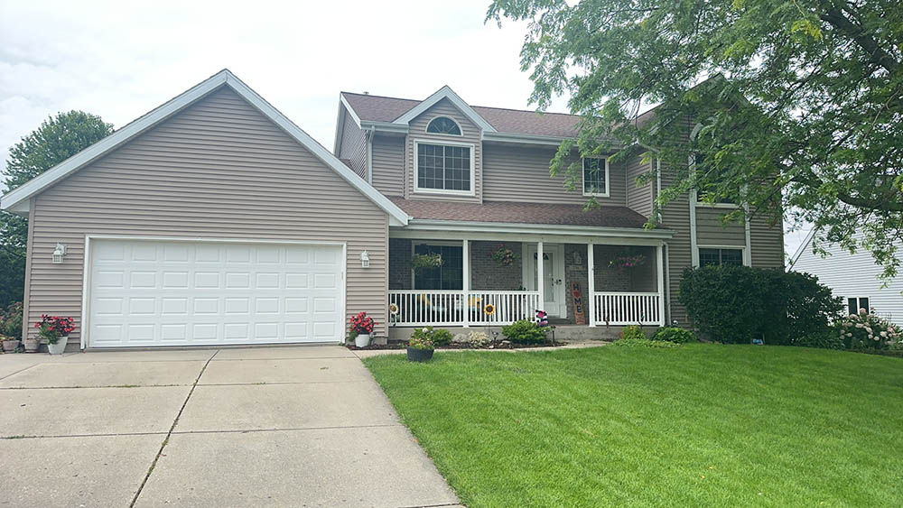A well-maintained two-story home with a landscaped front yard and a garage