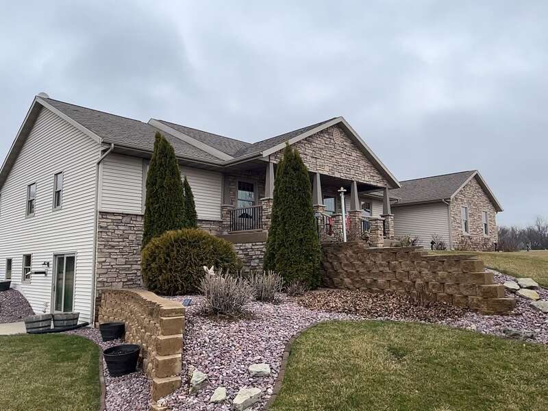 A well-maintained home featuring a combination of stone and siding exterior with landscaped steps