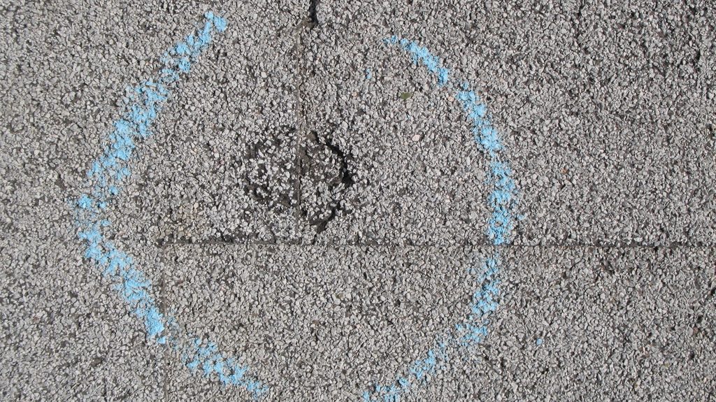 Close-up of hail impact marks on asphalt shingles showing granule loss in Madison Wisconsin
