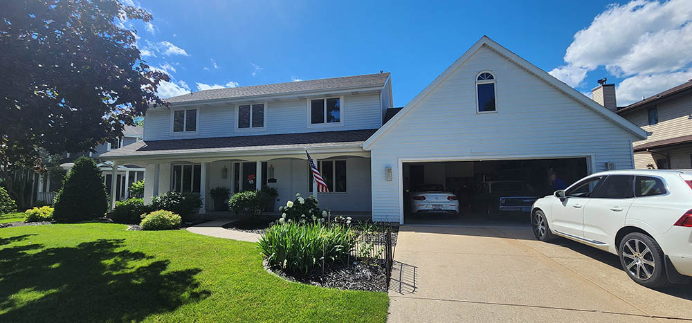 A well-maintained two-story home with a manicured lawn and a garage