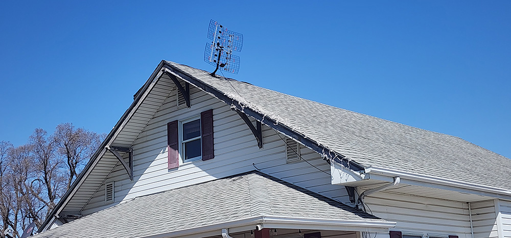 A well-maintained house with a new roof and an antenna on top
